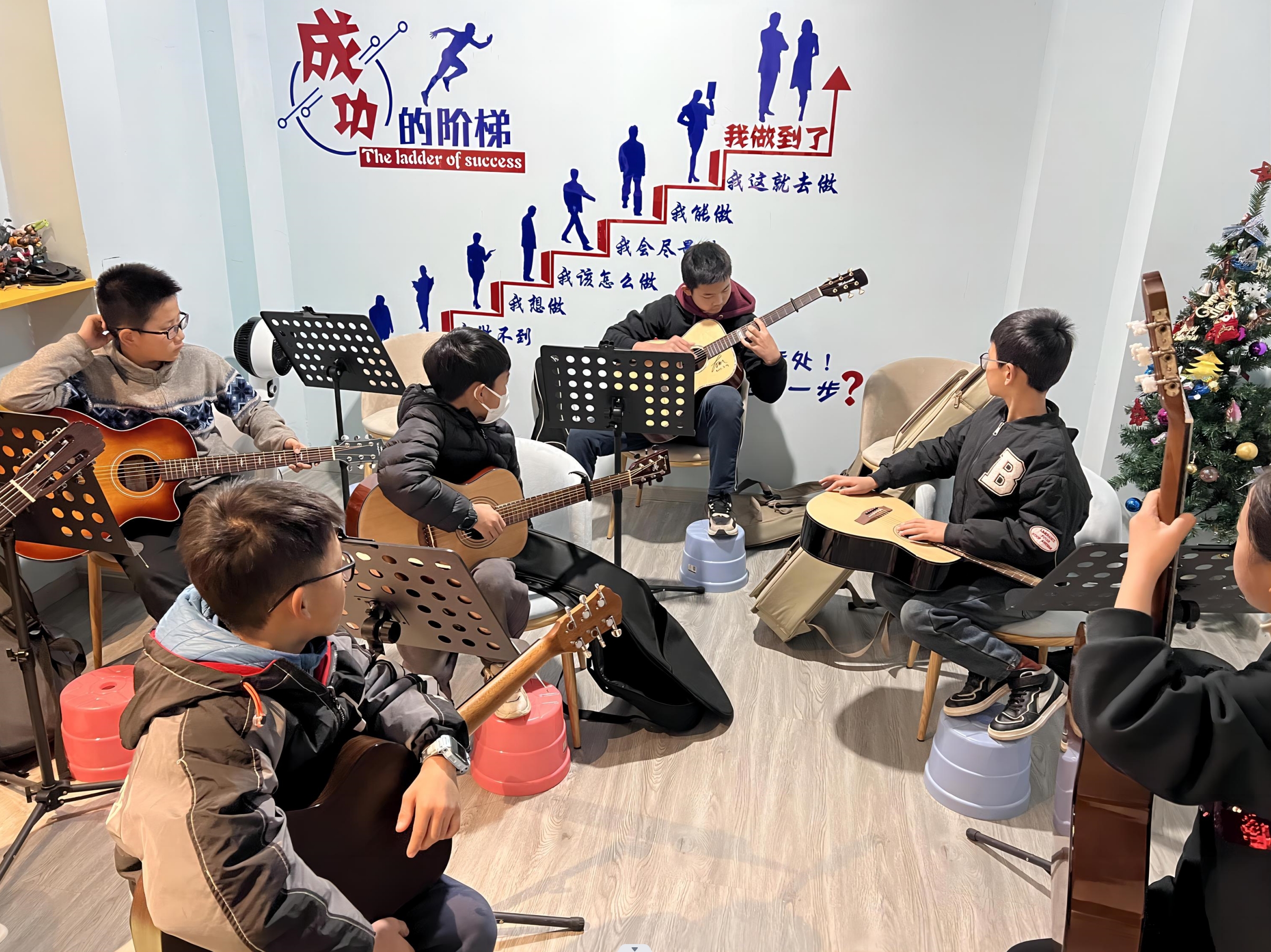 师哥坐在最后一排给弟弟妹妹们演奏新练的指弹曲目